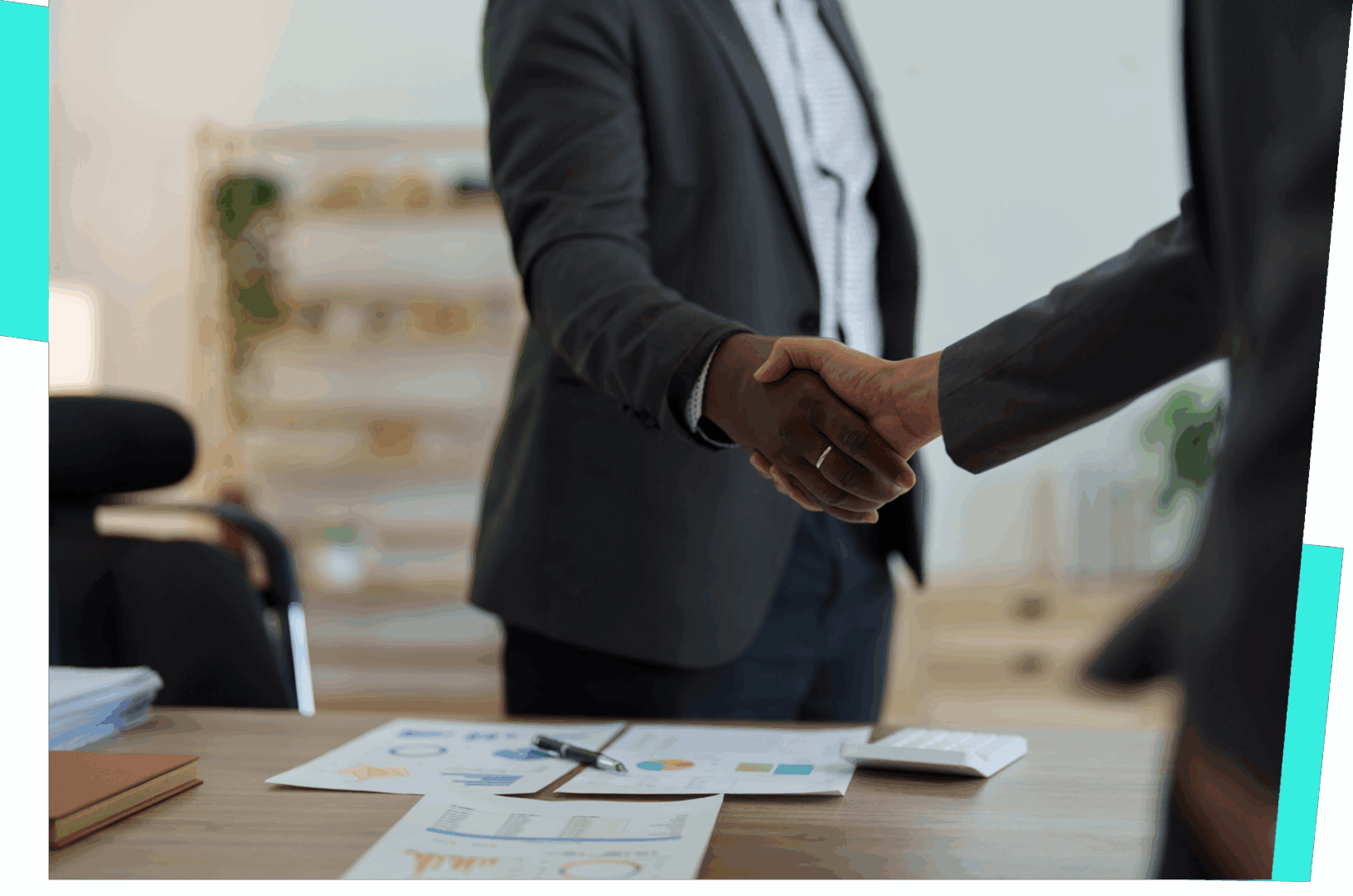 Two people shaking hands in office.